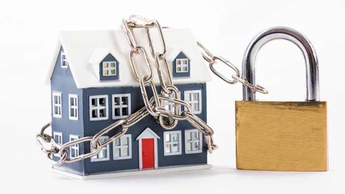 A house changed up with a padlock, indicating a mortgage prisoner.