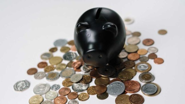 A piggybank with coins spilt out on the floor A piggybank with coins spilt out on the floor